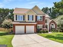 Inviting two-story home features a brick facade, two-car garage, and well-maintained landscaping at 2740 Greymont Ct, Cumming, GA 30041