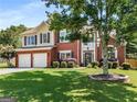Lovely two-story home with brick, siding, attached garage, and mature landscaping at 2740 Greymont Ct, Cumming, GA 30041