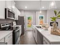 Bright kitchen boasts white cabinets, stainless steel appliances, and a center island with quartz countertops at 5615 Hislop Ln # 82, Mableton, GA 30126