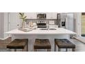 Modern kitchen featuring a large island with seating, stainless steel appliances, and sleek white cabinetry at 5615 Hislop Ln # 82, Mableton, GA 30126