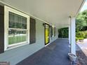 View of the covered front porch with a bright yellow door and a window with dark shutters at 644 Albert Nw St, Atlanta, GA 30318
