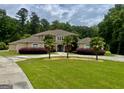 An elegant two-story home features a circular driveway, lush lawn, palm trees and landscaping and a beautiful facade at 345 Peaceful Way, Fayetteville, GA 30214