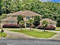 Beautiful home showcasing manicured landscaping, a circular driveway, and classic architectural design at 345 Peaceful Way, Fayetteville, GA 30214