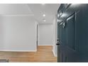 Bright entryway featuring wood-look flooring, freshly painted walls, and a stylish teal front door at 1280 W Peachtreestreetsuffix=Street Nw # 808, Atlanta, GA 30309