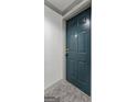 Close-up of a dark teal condo unit door featuring four raised panels and classic hardware at 1280 W Peachtreestreetsuffix=Street Nw # 808, Atlanta, GA 30309