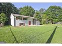 Spacious home showcasing a well-manicured lawn, white painted brick, dark shutters, and a charming red front door at 1349 Heather Cir, Riverdale, GA 30296