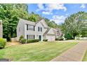 Suburban home featuring a well-kept lawn, mature trees, and a two-car garage at 2821 Amhurst Nw Way, Kennesaw, GA 30144