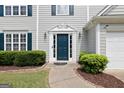 Inviting entryway featuring a blue front door, decorative sidelights, and manicured bushes at 2821 Amhurst Nw Way, Kennesaw, GA 30144