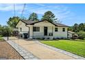 Lovely home showcasing a gated driveway and inviting exterior, surrounded by green lawn and mature trees at 4020 Ester Sw Dr, Atlanta, GA 30331