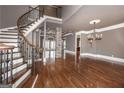 Elegant foyer featuring a curved staircase, hardwood floors, and stone pillar accent at 297 Collegiate Dr, Powder Springs, GA 30127