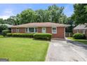 Charming brick home with a well-maintained lawn and mature landscaping at 135 5Th Ave, Jonesboro, GA 30236