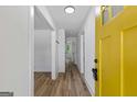Inviting entryway featuring wood-look floors, a view of the hallway, and a striking yellow front door at 1400 North Avenue Nw, Atlanta, GA 30318