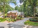 Stately brick home featuring a long driveway, mature trees, and manicured landscaping at 3506 Billingsley Dr, Marietta, GA 30062