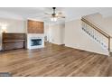 Spacious living room features a fireplace with brick accent wall, wood floors and a staircase at 79 The Farm Rd, Mcdonough, GA 30252