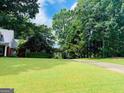View of a home, surrounded by lush greenery and a sprawling lawn at 149 Crown Oaks Dr, Stockbridge, GA 30281