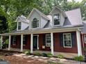 Charming brick home with a covered front porch and well-manicured landscaping at 149 Crown Oaks Dr, Stockbridge, GA 30281