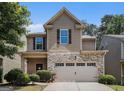 Charming home featuring a stone facade, a two-car garage, and lush landscaping at 2780 Lakeview Walk, Decatur, GA 30035