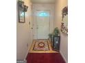 Inviting entryway with light wood floors, complemented by a decorative rug and a charming half-moon window at 7133 Babbling Brook Dr, Jonesboro, GA 30236