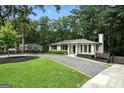 Beautiful single-story home with mature trees, gravel driveway, and lush green lawn at 2676 Cottonwood Dr, Marietta, GA 30066