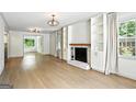 Bright living room featuring hardwood floors, a fireplace with built-in shelving, and ample natural light at 2676 Cottonwood Dr, Marietta, GA 30066