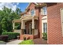Beautiful brick home with a charming front porch and detailed architectural features at 200 Long Needle Ct, Sugar Hill, GA 30518
