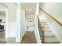 Bright foyer with hardwood floors, staircase, and decorative columns leading to an open floor plan at 232 Shelton Cir, Temple, GA 30179