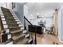 Entryway showcasing hardwood floors, carpeted stairs, and a view of the living room with a fireplace at 435 Hampton Grn, Peachtree City, GA 30269