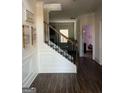 Inviting foyer with hardwood floors, decorative wainscoting, staircase, and stylish decor at 2208 Ginger Lake Ne Dr, Conyers, GA 30013