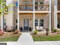 Inviting townhome exterior featuring a cozy porch with seating, lush landscaping, and a charming entryway at 4065 Holland Grove, Lawrenceville, GA 30044