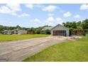 Ranch home with driveway, lush lawn and mature trees at 1587 Cronic Town Rd, Auburn, GA 30011