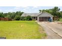 Lush front lawn, driveway, and mature trees in a ranch-style home at 1587 Cronic Town Rd, Auburn, GA 30011