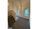 Carpeted hallway and staircase featuring neutral colors and natural lighting at 101 Dancing Fox Rd, Decatur, GA 30032