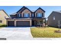Two-story brick home featuring a three-car garage, black shutters and a manicured lawn at 1172 Faulkner Way, Jonesboro, GA 30238
