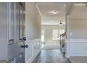 Hallway with hardwood floors, wood trim, and view into the living room with stairs and carpet at 1172 Faulkner Way, Jonesboro, GA 30238