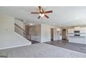 Open living room with carpet, access to hardwood hallway, staircase, and open view to kitchen at 1172 Faulkner Way, Jonesboro, GA 30238