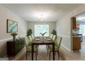 Inviting dining room with large window, chandelier, and view of a light-filled kitchen at 260 Redding Rdg, Atlanta, GA 30349