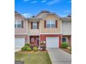 Well-kept townhome boasts a one-car garage, brick facade, and professionally landscaped front yard at 2083 Hasel St, Lawrenceville, GA 30044
