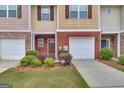 Close-up of a townhome with a single-car garage, brick accents, and neatly trimmed landscaping at 2083 Hasel St, Lawrenceville, GA 30044