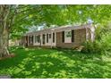 Charming brick home with a well-manicured lawn surrounded by lush greenery at 2826 Summit Ridge Dr, Marietta, GA 30066