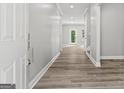 Modern hallway with wood-look flooring, neutral walls, and plenty of natural light at 5341 Stewart Mill Rd, Douglasville, GA 30135