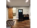 Inviting entryway with wood floors, hall tree, and barn door leading to a bathroom at 2410 Thrasher Rd, Buford, GA 30519