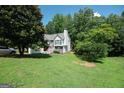 Well-maintained home with a spacious lawn and mature trees providing shade and privacy at 7030 Wessex Way, Cumming, GA 30028