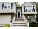 Inviting front entrance features a classic black door with an arched window and wood stairs with white railings at 7030 Wessex Way, Cumming, GA 30028