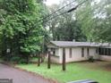 Modest single-story home featuring neutral siding and a screened-in porch, nestled in a wooded landscape at 125 Highland Cir, Stockbridge, GA 30281