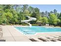 Resort-style community pool and waterslide surrounded by lounge chairs and lush greenery at 826 Richmond Cir, Peachtree City, GA 30269