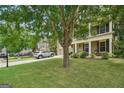 Landscaped front yard showcasing a two-story house with large front porch and mature trees at 826 Richmond Cir, Peachtree City, GA 30269