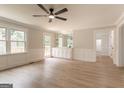Bright living room featuring a ceiling fan, hardwood floors, and a bar area with cabinets at 5674 Mountain Cres, Stone Mountain, GA 30087