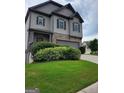This home has a beautiful stone facade, gray siding, two car garage, and green lawn at 2424 Saint Andrews Rdg, College Park, GA 30337