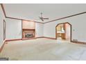 Bright living room with a brick fireplace, wood trim, and neutral carpet at 936 Bo Bo Banks Rd, Grantville, GA 30220
