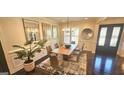 Bright dining room with large windows, modern decor and seating for eight guests at 4564 Investors Ln, Ellenwood, GA 30294